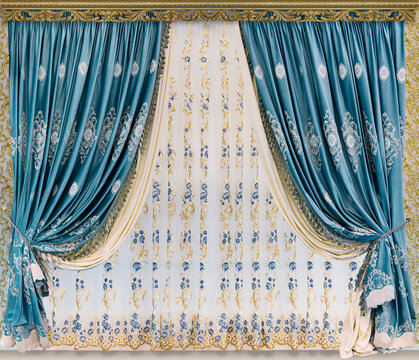 Stylish design of window and doorways. Luxurious blue embroidered curtains and light tulle from organza with ornament