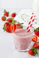 Strawberry smoothie or milkshake with berries and oatmeal in glass jar on gray or white concrete background. Vegetarian healthy drink. Close up. Selective focus.