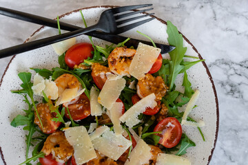 top view of salad with arugula, shrimps and parmesan cheese