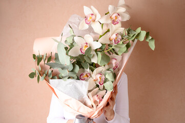 Woman holding a beautiful bouquet with flowers on green background. Front view. Valentine's,...