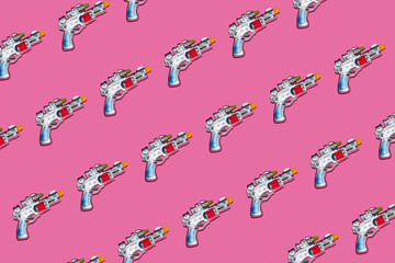 Creative pattern made with space gun toy on bright pink background. Fun creative idea. Flat lay.