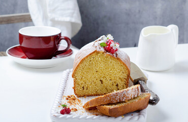 Plum cake with yougurt and with red currant over  white wooden tray.
