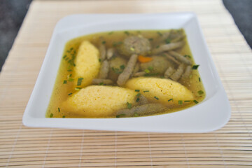 Suppe mit Nockerl, Leberspätzle, kleinen Leberknödel , Kurkuma und Kräutern servieren