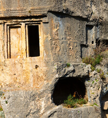 Remains of ancient Lycian rock hewn tombs in stone cliff in city of Tlos, Mugla Province, Turkey