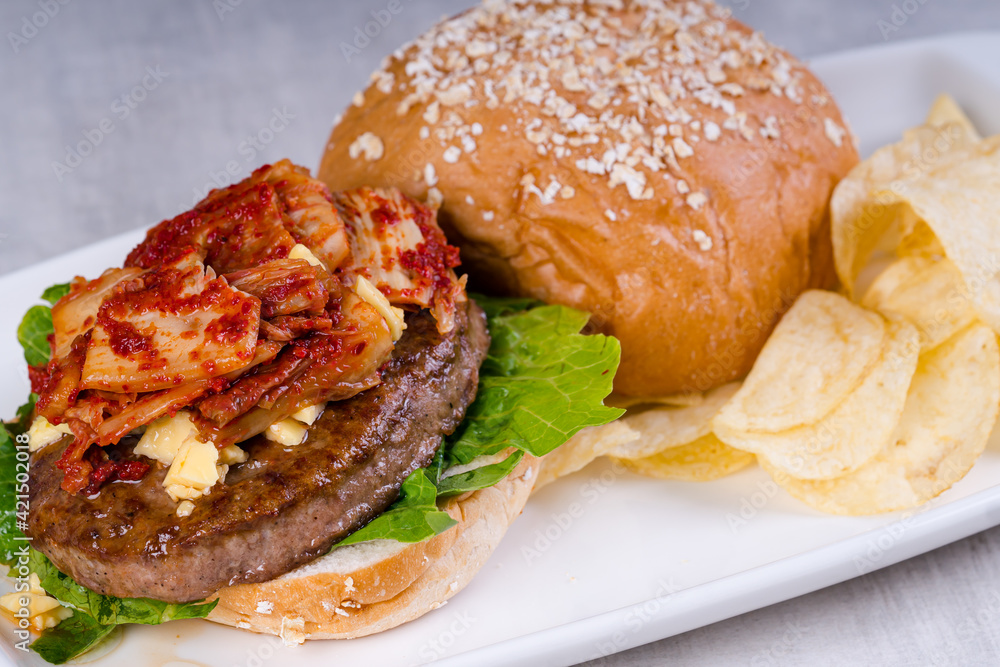 Wall mural gourmet kimchi angus beef burger with potato chips on the side