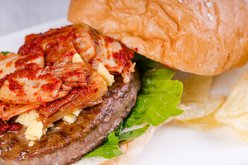 gourmet kimchi angus beef burger with potato chips on the side