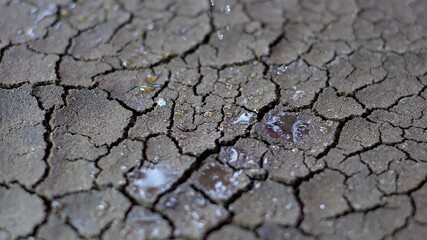 Water Drops Fall On Dry Fractured Soil Of Drought
