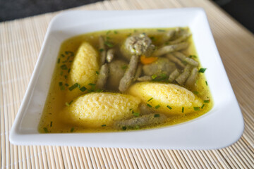 Suppe mit Nockerl, Leberspätzle, kleinen Leberknödel , Kurkuma und Kräutern servieren