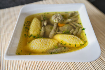 Suppe mit Nockerl, Leberspätzle, kleinen Leberknödel , Kurkuma und Kräutern servieren