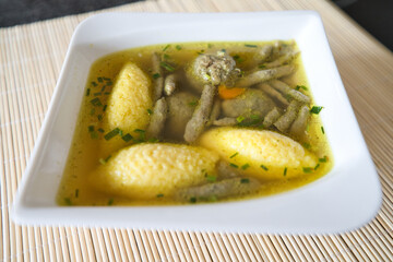 Suppe mit Nockerl, Leberspätzle, kleinen Leberknödel , Kurkuma und Kräutern servieren