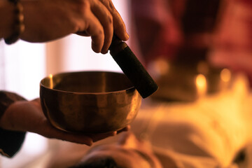 Soft focus view of a woman practicing holistic activities with Tibetan bells. Meditation and...