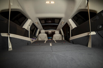 huge empty car trunk in premium light color interior of suv. rear seats in premium car folded in...