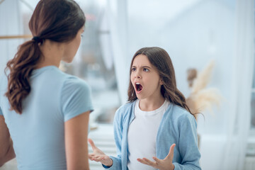 Angry screaming teen girl and listening mom - obrazy, fototapety, plakaty