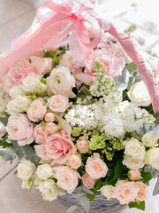 A basket with delicate colors. Roses, ranunculi, lilacs. Spring bouquet as a gift to your beloved. Beautiful floral arrangement