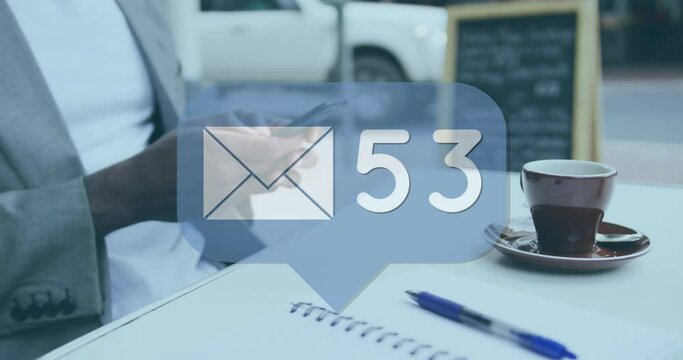 Message icon with increasing numbers against mid section of man using smartphone at cafe