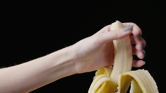 Video of female hand squashing banana