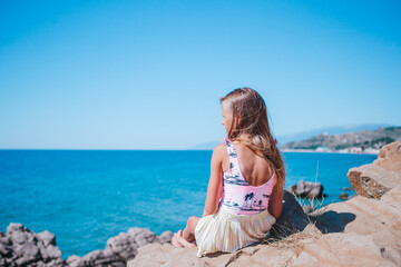 Fototapeta na wymiar Little girl outdoor on edge of cliff seashore