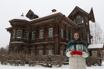 Russian woman, girl. Pogorelovo terem. Wooden house with carved windows, ornamental frames in...