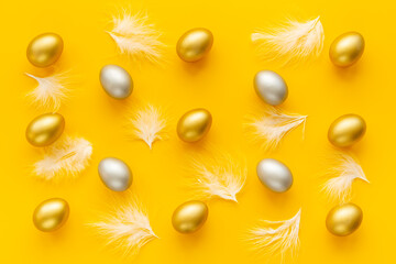 Golden and silver Easter eggs with white feather. Easter decoration, top view