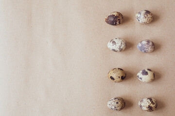 Fototapeta na wymiar Variegated quail eggs on a brown paper background.