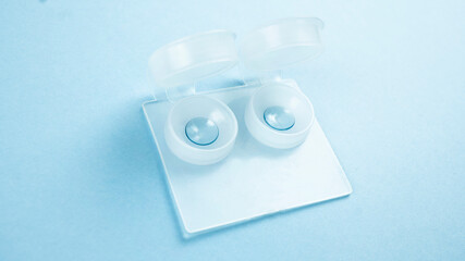 A pair of hard lenses in a container case for nearsighted people. Selective focus on a blue...
