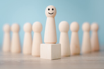 Wood person model among people Smiling .Successful team leader concept.
