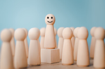 Wood person model among people Smiling .Successful team leader concept.