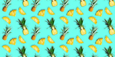 Seamless pattern of ripe pineapples isolated on green background. Top view. Tropical fruit summer exotic concept