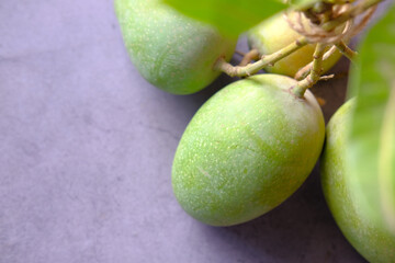 Fresh green mango on black background top down.