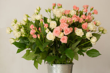 Bouquet of small delicate pink and cream roses in a vase