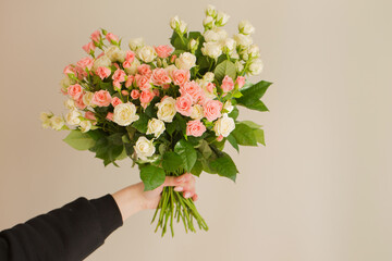 Naklejka premium Bouquet of pink and cream roses in female hands