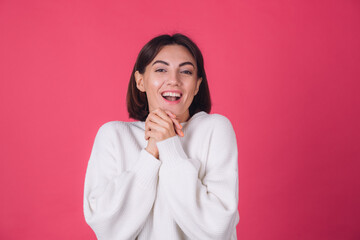 Woman in white casual sweater on red pink background copy space cheerful excited amazed look to camera