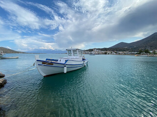 Fototapeta na wymiar Elounda harbour with white boat