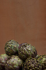 Obraz premium Fresh artichokes with light brown background in Rome, Italy