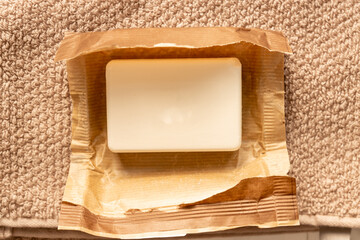 Close up of soap br in paper craft package on towel background. Eco friendly space and personal...