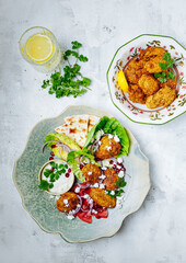 Falafel with tomatoes, red onion, flatbread and yogurt tahini sauce