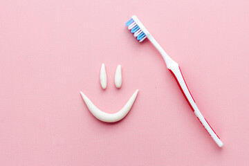 Smile shape of toothpaste with toothbrush, top view. Oral care and hygiene