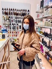 girl in a protective mask in a cosmetics store. Covid-19
