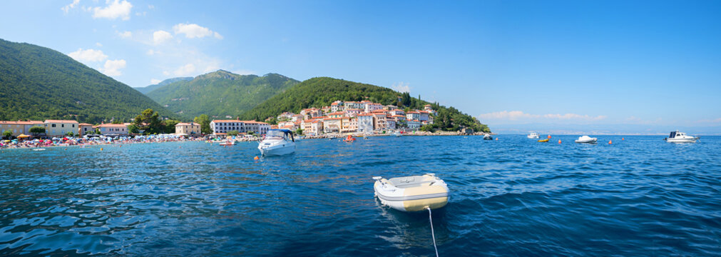 panorama coastal landscape Moscenicka Draga tourist resort with boats and bathing beach, ucka mountains