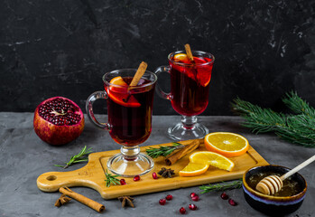 mulled wine in a transparent glass. orange, pomegranate, cinnamon, cardamom, spices. fruit compote. pomegranate tea. warming drink 