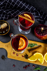 Obraz na płótnie Canvas mulled wine in a transparent glass. orange, pomegranate, cinnamon, cardamom, spices. fruit compote. pomegranate tea. warming drink 