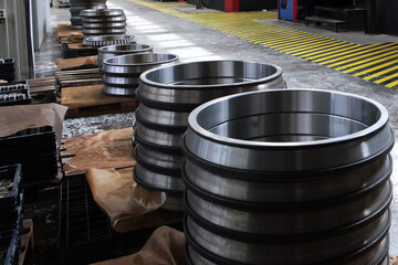 Ready-made large-diameter bearings stand in rows at factory.Finished products of the bearing plant.A large number of large size bearings. Heavy industry concept. Metal products.