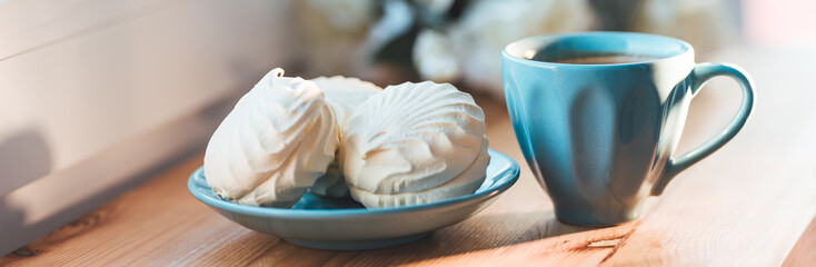Cup of coffee with marshmallows and on a wooden table