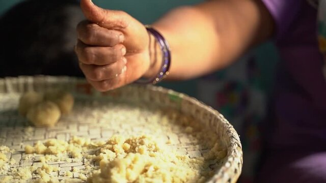 Woman making thekua by hand for chhath puja