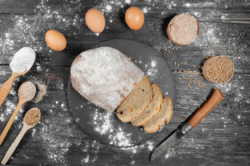 Freshly baked homemade rye sourdough bread. Sliced. spoon and eggs lie side by side. View from above.