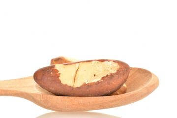 Two delicious organic Brazil nuts with wooden spoon, close-up, isolated on white.