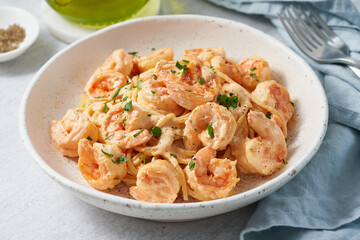 Pasta spaghetti with grilled shrimps bechamel sauce. Spaghetti with seafood rich cream. Cooking mediterranean food with savory prawns, blue table, italian cuisine