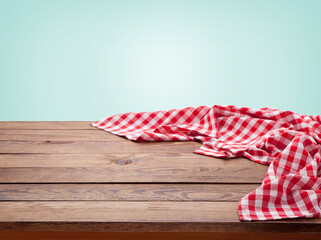 Red checkered tablecloth on wooden table. Napkin close up top view mock up. Kitchen rustic...