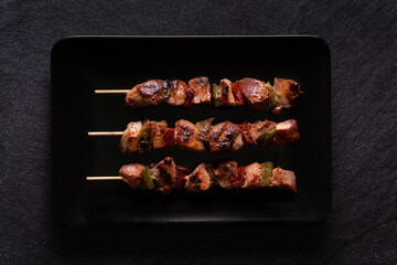 Made pieces of chicken with red and green peppers on skewers