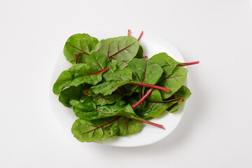 Some chard leaves or mangold in white plate on a white background